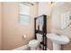 Powder room with a pedestal sink, decorative mirror, storage cabinet, and neutral color scheme at 7506 Sabino Ln, Castle Rock, CO 80108