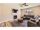 Comfortable living room featuring a fireplace, modern fan, and a dark leather couch at 7506 Sabino Ln, Castle Rock, CO 80108