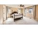 Bright main bedroom features neutral walls, a ceiling fan, two windows, and a traditional-style bed with matching side tables at 7506 Sabino Ln, Castle Rock, CO 80108
