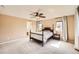 Bright main bedroom features neutral walls, a ceiling fan, two windows, and a traditional-style bed with matching side tables at 7506 Sabino Ln, Castle Rock, CO 80108