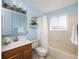 This bathroom features a classic design with blue walls and a wood vanity at 11381 Jay St, Westminster, CO 80020