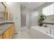 Bright bathroom with a separate tub, shower, double sink with wood cabinets, and tile backsplash at 1033 Bramblewood Dr, Castle Pines, CO 80108