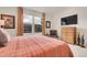 Well-lit bedroom with neutral walls, large windows with curtains, and a wall-mounted TV at 1033 Bramblewood Dr, Castle Pines, CO 80108