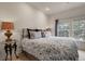 Bedroom with decorative lamps, patterned bedding, and a window with backyard views at 1033 Bramblewood Dr, Castle Pines, CO 80108