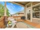 Inviting covered deck with comfortable seating, a grill, and a view of the well-maintained backyard at 1033 Bramblewood Dr, Castle Pines, CO 80108