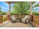 Relaxing covered deck featuring comfortable chairs, a small table, and beautiful outdoor views at 1033 Bramblewood Dr, Castle Pines, CO 80108
