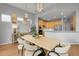 Spacious dining area with a light wood table, modern lighting, and an open view to the kitchen at 1033 Bramblewood Dr, Castle Pines, CO 80108