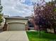 Charming single-Gathering home features a two-car garage, brick accents, and a well-manicured front lawn at 1033 Bramblewood Dr, Castle Pines, CO 80108