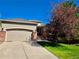 Attractive single-Gathering home with a two-car garage, brick accents, and mature trees on the property at 1033 Bramblewood Dr, Castle Pines, CO 80108