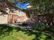 Welcoming home entrance featuring brick accents, a cozy seating area, and lush landscaping at 1033 Bramblewood Dr, Castle Pines, CO 80108