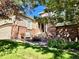 Charming home entrance with brick accents, a cozy chair, and beautiful flowerbeds at 1033 Bramblewood Dr, Castle Pines, CO 80108