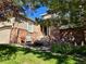 Inviting home entrance featuring brick accents, a comfortable chair, and a beautifully landscaped front yard at 1033 Bramblewood Dr, Castle Pines, CO 80108