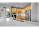 Modern kitchen with stainless steel appliances, light wood cabinets, and white countertops at 1033 Bramblewood Dr, Castle Pines, CO 80108