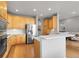 Bright kitchen with wood cabinets, stainless steel refrigerator, countertops and hardwood floors at 1033 Bramblewood Dr, Castle Pines, CO 80108