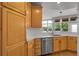 Sunny kitchen featuring wooden cabinets, stainless steel appliances, and a window overlooking the backyard at 1033 Bramblewood Dr, Castle Pines, CO 80108