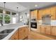 Open kitchen offers a gas range, stainless steel appliances, and views to the backyard at 1033 Bramblewood Dr, Castle Pines, CO 80108