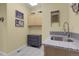 Bright laundry room featuring gray cabinets, granite counters, tile backsplash, and decor at 1033 Bramblewood Dr, Castle Pines, CO 80108