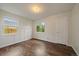 Light filled bedroom with dark laminate flooring, two windows and white trim at 1909 Iola St, Aurora, CO 80010