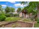 Spacious backyard featuring a garden bed, wooden deck, and mature trees at 4210 S Fox St, Englewood, CO 80110