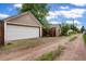 View of the detached two-car garage with ample space, complemented by a dirt road at 4210 S Fox St, Englewood, CO 80110