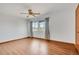 Bright bedroom featuring wood floors, ceiling fan, and window with curtains at 8911 W Yale Ave, Lakewood, CO 80227