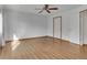 Bedroom with wood floors, a ceiling fan, and a door shows a clean and minimalist design, offering a comfortable living space at 8911 W Yale Ave, Lakewood, CO 80227