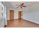 Bedroom featuring wood floors, ceiling fan, and window with white curtains at 8911 W Yale Ave, Lakewood, CO 80227