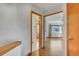 Hallway with wood floors leads to rooms with neutral walls and wood trim, showing access to various parts of the home at 8911 W Yale Ave, Lakewood, CO 80227