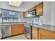 Well-lit kitchen with stainless steel appliances, granite countertops, wooden cabinets, and a large window at 8911 W Yale Ave, Lakewood, CO 80227