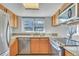 Bright kitchen featuring stainless steel appliances, granite countertops, wooden cabinets, and a hood vent at 8911 W Yale Ave, Lakewood, CO 80227