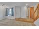Bright living room boasts neutral carpet, fresh white walls, and easy access to a half bath at 8911 W Yale Ave, Lakewood, CO 80227