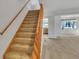 Carpeted staircase with wood railing leading to the upper level, providing access to the home's living spaces at 8911 W Yale Ave, Lakewood, CO 80227