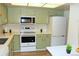 Bright kitchen with updated white appliances and green cabinets at 13890 E Marina Dr # 612, Aurora, CO 80014