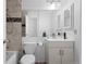 Compact bathroom featuring a toilet, sink, cabinet and mirror at 23 S Nome St # A, Aurora, CO 80012