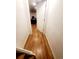 Hallway view featuring hardwood floors and white walls, leading to a bright room with a visible desk at 23 S Nome St # A, Aurora, CO 80012