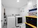 Bright laundry room with a washer and dryer, storage cabinets, and white tiled flooring at 23 S Nome St # A, Aurora, CO 80012
