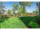 Large backyard features a well-manicured lawn, mature trees, and privacy fencing at 10155 Riverstone Dr, Parker, CO 80134