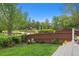 Landscaped back yard features a wood fence, lawn and planting beds with distant view of a playground at 10155 Riverstone Dr, Parker, CO 80134