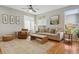 Bright living room with a comfortable couch, armchair, and ample natural light showcasing hardwood floors and neutral decor at 10155 Riverstone Dr, Parker, CO 80134