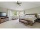 Spacious main bedroom with a wooden bed frame, neutral decor, and ample natural light from large windows at 10155 Riverstone Dr, Parker, CO 80134