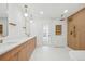 Well-lit bathroom features double vanity, a large mirror, and a modern, wood-paneled shower at 7000 W Stetson Pl # 9, Littleton, CO 80123