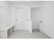 Neat mudroom with white walls, modern tile floor, bench and closet for storage at 7000 W Stetson Pl # 9, Littleton, CO 80123