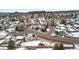 An aerial view showcases a snow-covered neighborhood with a mountain in the background at 1206 Baldwin Park Cir, Castle Rock, CO 80104