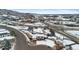 An aerial view showcases a snow-covered home with a roundabout and nearby businesses at 1206 Baldwin Park Cir, Castle Rock, CO 80104