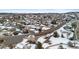 A snow-covered suburban neighborhood is depicted from an aerial perspective, featuring houses along a street at 1206 Baldwin Park Cir, Castle Rock, CO 80104