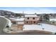 Exterior view of home with attached garage, snow in yard and view of mountains at 1206 Baldwin Park Cir, Castle Rock, CO 80104