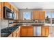 Well-lit kitchen featuring wood cabinets, a gas range, and stainless steel appliances at 1206 Baldwin Park Cir, Castle Rock, CO 80104