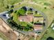 Property featuring fenced horse areas, a red barn, and circular driveway at 17450 E 14Th Dr, Aurora, CO 80011