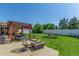 Inviting backyard featuring a shaded patio, outdoor seating, a cozy fire pit, and ample green space at 17450 E 14Th Dr, Aurora, CO 80011