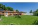 Expansive backyard featuring a large lawn, patio, and charming pergola-covered outdoor dining area at 17450 E 14Th Dr, Aurora, CO 80011